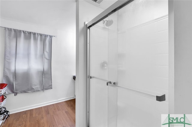 bathroom featuring a shower with door and hardwood / wood-style floors