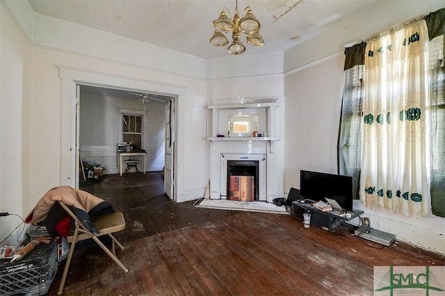 living room with a chandelier, wood-type flooring, and a fireplace