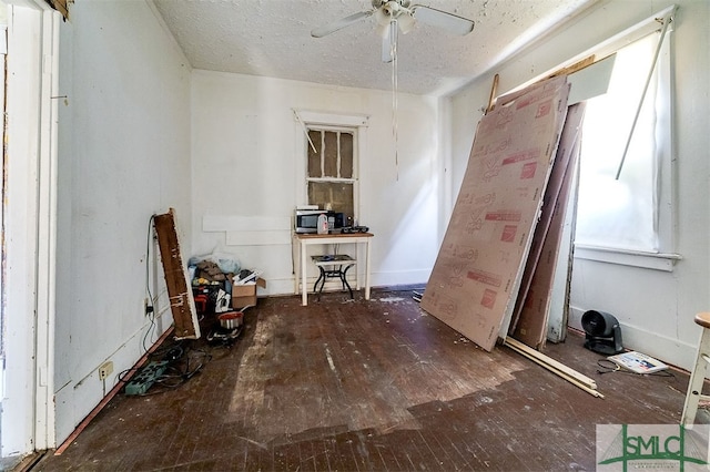 misc room featuring a textured ceiling, dark hardwood / wood-style flooring, and ceiling fan