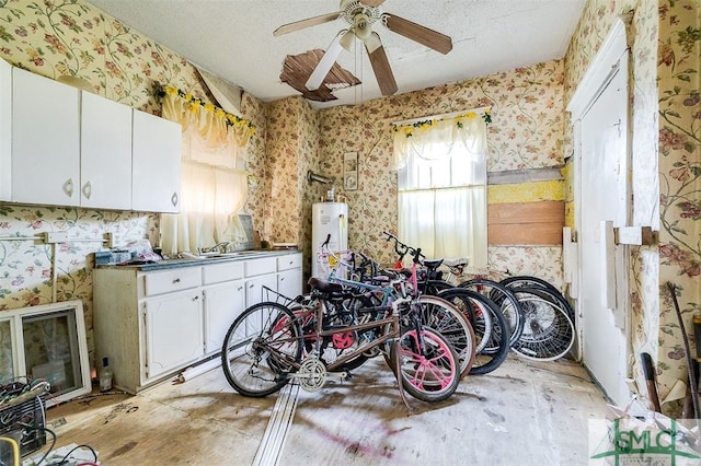 garage featuring gas water heater, ceiling fan, and sink