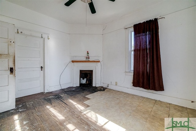 unfurnished living room with ceiling fan and a fireplace