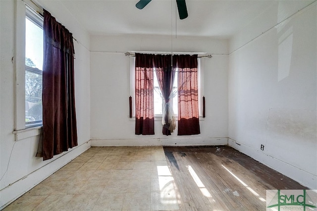 empty room featuring a wealth of natural light and ceiling fan