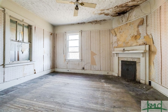 unfurnished living room with ceiling fan, dark hardwood / wood-style flooring, and a fireplace