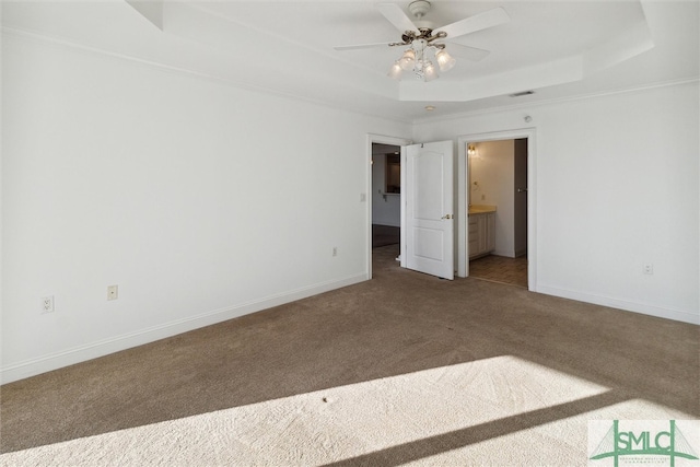 empty room featuring ceiling fan, carpet, and a tray ceiling