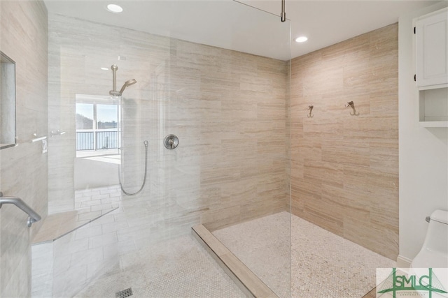 bathroom featuring a tile shower and tile patterned flooring