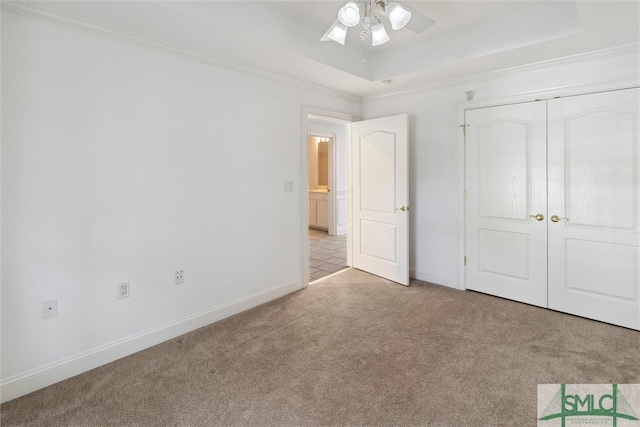 unfurnished bedroom featuring a closet, ceiling fan, ornamental molding, and light colored carpet