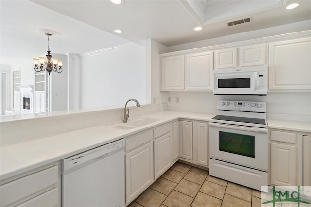 kitchen featuring white appliances, sink, white cabinetry, light tile patterned floors, and an inviting chandelier