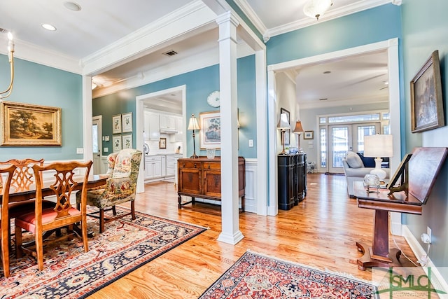 living area featuring french doors, light hardwood / wood-style floors, and ornamental molding