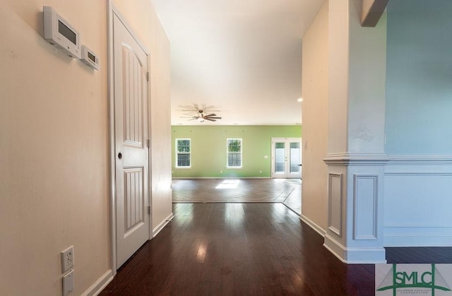 corridor featuring baseboards, wood finished floors, and french doors