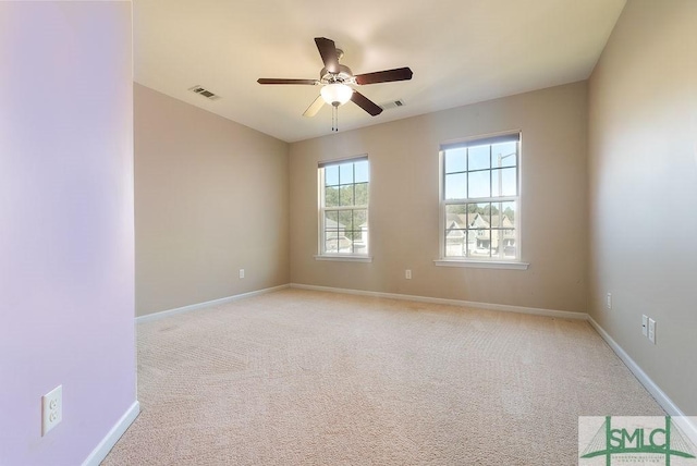 empty room featuring baseboards, visible vents, and light colored carpet