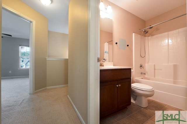 bathroom featuring baseboards, toilet, tile patterned floors, vanity, and shower / washtub combination