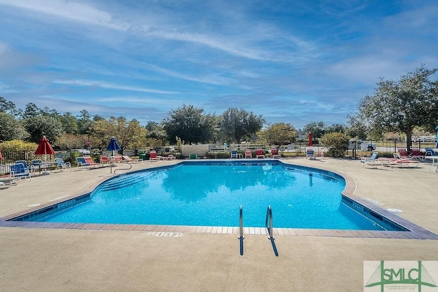 pool featuring fence and a patio