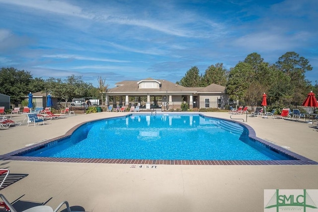 community pool featuring a patio and fence