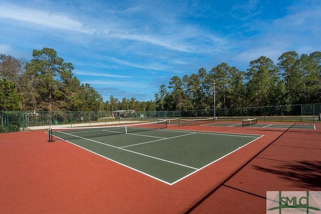 view of tennis court featuring community basketball court and fence