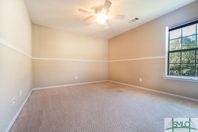 carpeted spare room featuring a wealth of natural light, visible vents, and baseboards