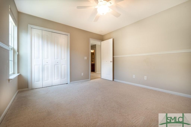 unfurnished bedroom with ceiling fan, a closet, carpet, and baseboards