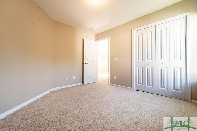 unfurnished bedroom featuring carpet floors, baseboards, and a closet