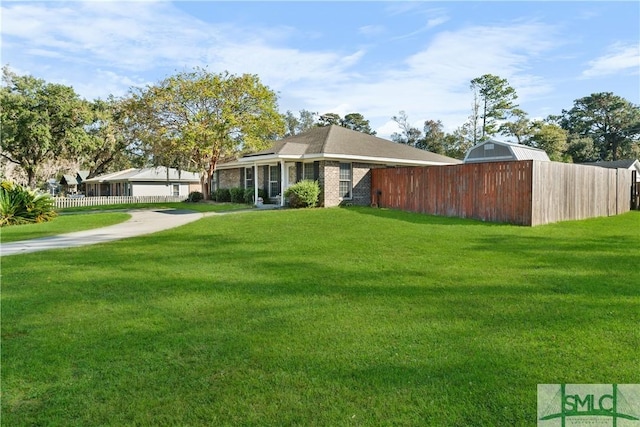 view of yard with an outbuilding, a pole building, and fence