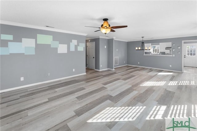 unfurnished living room featuring visible vents, baseboards, and crown molding