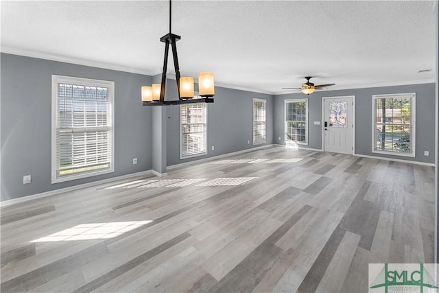 interior space with a textured ceiling, wood finished floors, and ornamental molding