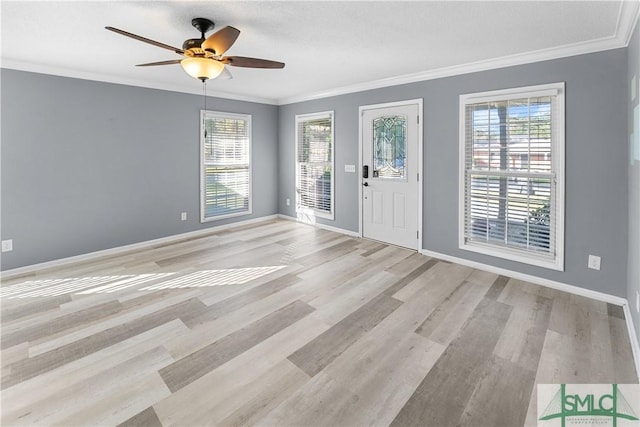 foyer entrance with a ceiling fan, light wood-type flooring, baseboards, and ornamental molding