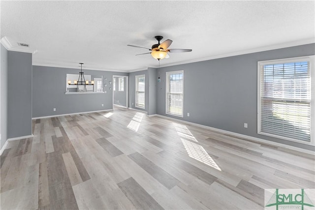 empty room featuring light wood-type flooring, ceiling fan with notable chandelier, a textured ceiling, crown molding, and baseboards