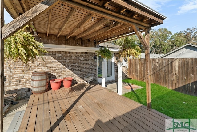 wooden terrace featuring fence and a lawn