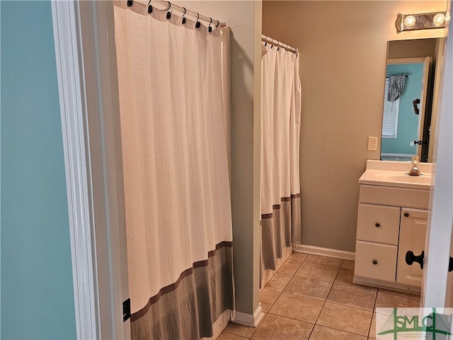 bathroom featuring tile patterned flooring, curtained shower, vanity, and baseboards