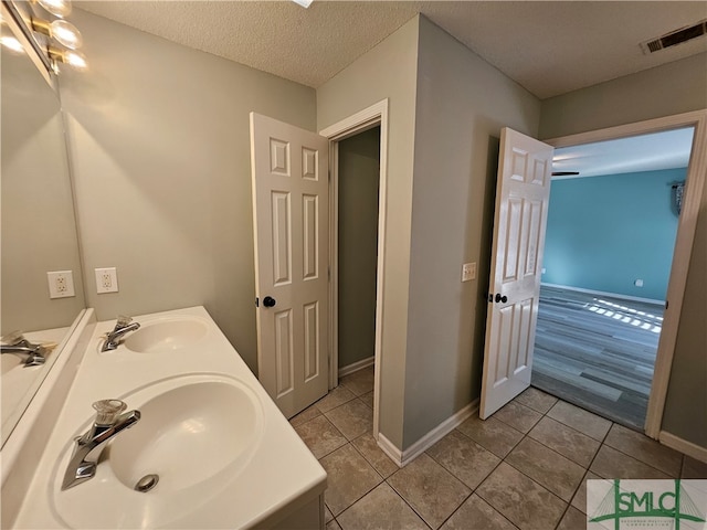 bathroom featuring a sink, visible vents, a textured ceiling, and tile patterned floors