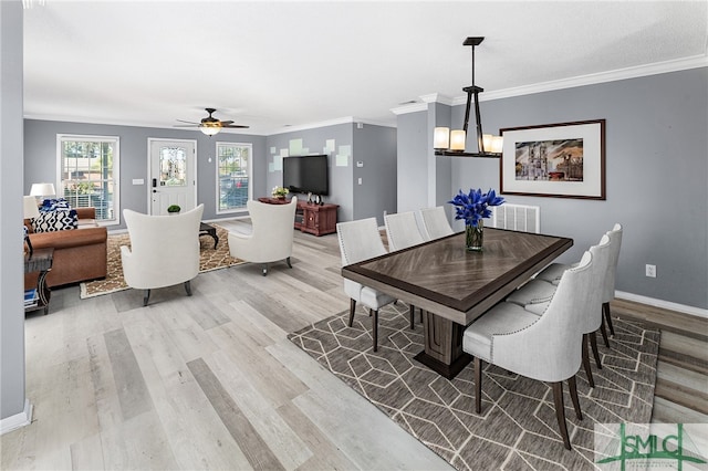 dining area with ornamental molding, ceiling fan with notable chandelier, and light hardwood / wood-style flooring