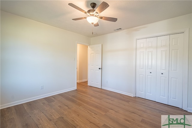 unfurnished bedroom featuring a closet, ceiling fan, a textured ceiling, and hardwood / wood-style floors