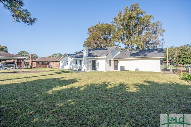 rear view of house with a yard and central AC unit