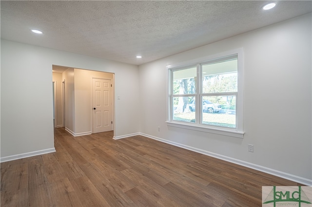 unfurnished room featuring a textured ceiling and hardwood / wood-style flooring