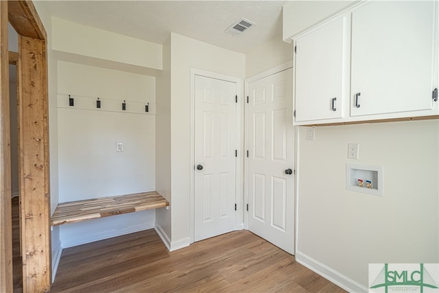 mudroom with a textured ceiling and light wood-type flooring