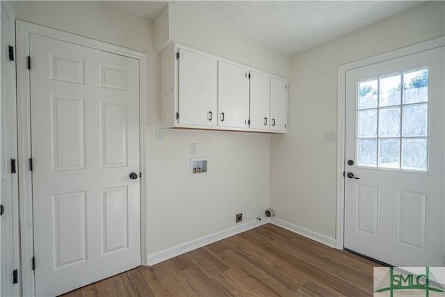 laundry area with a textured ceiling, washer hookup, cabinets, and hardwood / wood-style floors