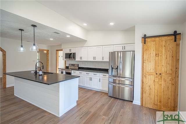 kitchen featuring vaulted ceiling, stainless steel appliances, sink, and white cabinets