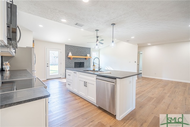 kitchen featuring appliances with stainless steel finishes, sink, pendant lighting, white cabinets, and light hardwood / wood-style flooring