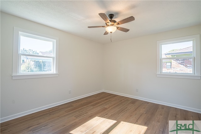 spare room with hardwood / wood-style floors, a textured ceiling, and ceiling fan