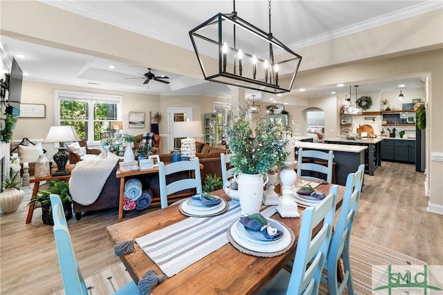 2203 River Oaks Dr, Richmond Hill, GA 31324 - dining room featuring crown molding, light wood-style floors, arched walkways, recessed lighting, and ceiling fan with notable chandelier