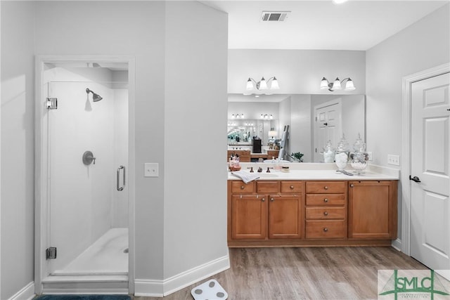 2203 River Oaks Dr, Richmond Hill, GA 31324 - full bathroom with wood finished floors, visible vents, vanity, and a stall shower
