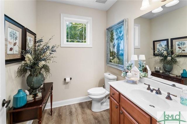 2203 River Oaks Dr, Richmond Hill, GA 31324 - half bath with visible vents, baseboards, toilet, wood finished floors, and vanity