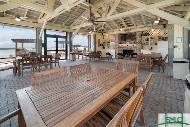 2203 River Oaks Dr, Richmond Hill, GA 31324 - dining area with ceiling fan, brick floor, and an outdoor brick fireplace