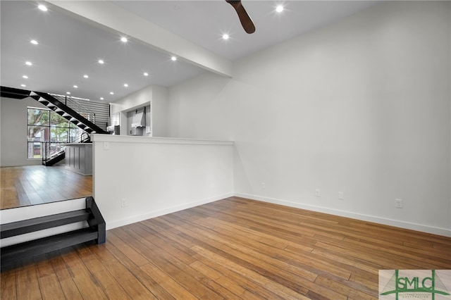 interior space with beam ceiling, light wood-type flooring, and ceiling fan