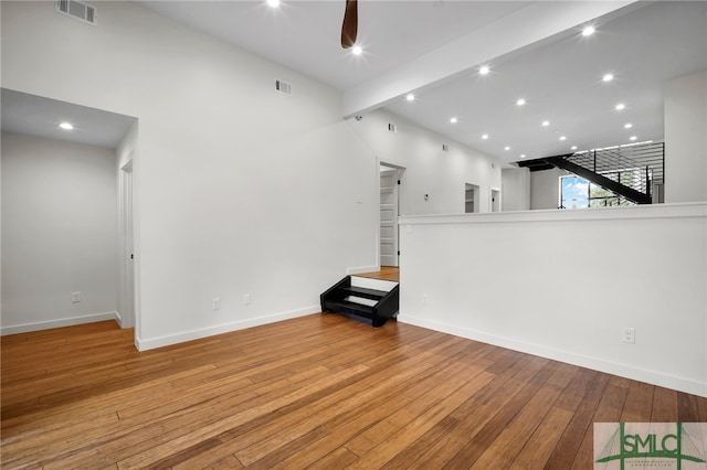 unfurnished living room with beam ceiling, light wood-type flooring, and ceiling fan