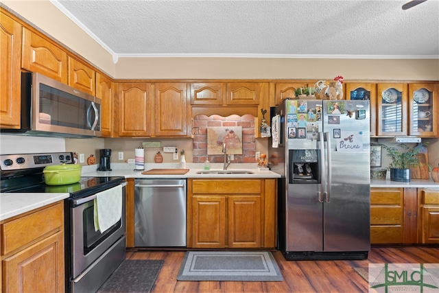 kitchen featuring sink, dark wood-type flooring, appliances with stainless steel finishes, and crown molding