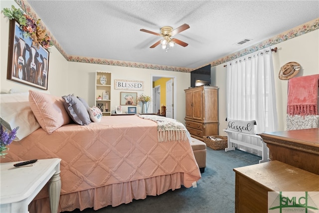 bedroom featuring dark colored carpet, a textured ceiling, and ceiling fan