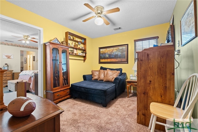 interior space featuring light carpet, a textured ceiling, and ceiling fan