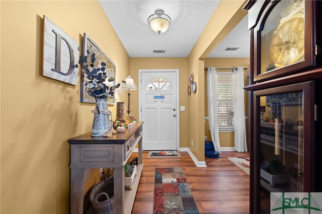 entryway with a textured ceiling and dark wood-type flooring