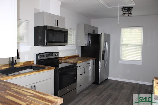 kitchen featuring wood counters, dark hardwood / wood-style flooring, sink, and appliances with stainless steel finishes