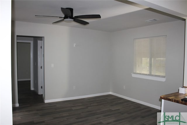 empty room with ceiling fan and dark hardwood / wood-style flooring